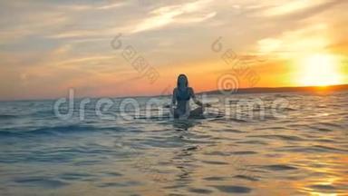 在海里休息的女人。 女运动员骑完一圈后就在冲浪板上冥想.